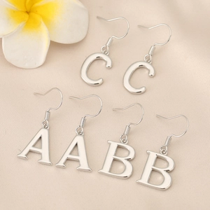 Polished silver alphabet A B C drop earrings on silk fabric with frangipani flower