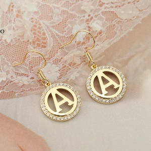 Detail of gold letter A drop earrings with sparkling rhinestones and elegant fish hooks