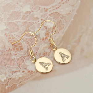 Close-up of 18K gold plated letter A earrings featuring sparkling pave-set rhinestones
