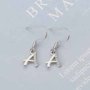 Nahaufnahme der Kupferohrringe mit Buchstabe A, Zirkonia-Inlay und 18K Gold-Finish
