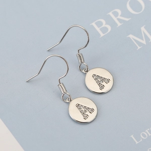 Macro view of silver copper letter A earrings with inlaid zircon details