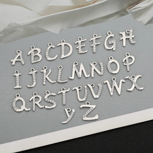 Nahaufnahme von silbernen A-Z Buchstaben-Anhängern mit feinen Zirkonia-Steinen