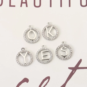 Close-up of 18K gold plated letter pendants with micro-set zircon for DIY jewelry