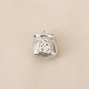 Detailed close-up of a silver lucky money bag charm with ancient coin relief and ring