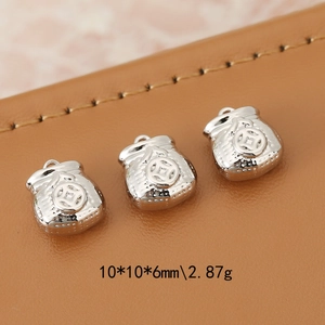 Three silver color lucky money bag pendants for DIY jewelry making on leather background