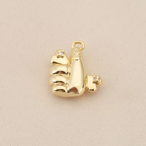 Macro shot of 18K gold plated thumb-up pendant with sparkling zircon inlays