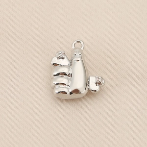 Macro detail of a thumb gesture pendant in silver finish with sparkling zircon stones