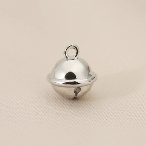 Macro shot of polished silver bell pendant with a round ring for jewelry making