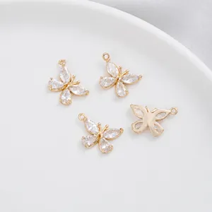Macro detail of 18K gold-plated butterfly charms with marquise cubic zirconia inlay