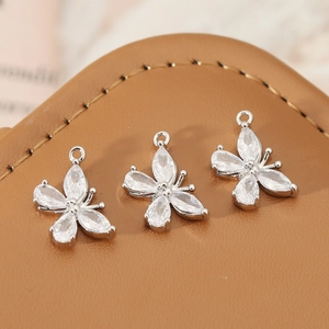 Detailed close-up of three 18K gold-plated butterfly pendants with cubic zirconia for DIY