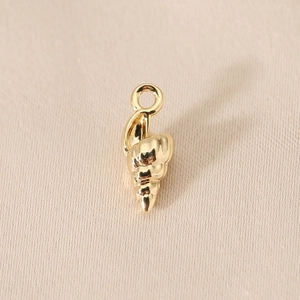 Macro shot of a 14K gold-plated conch shell pendant for DIY jewelry making with a smooth finish