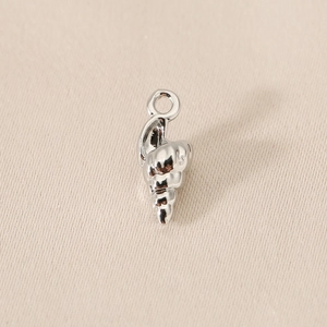 Macro detail of high-polished silver conch shell pendant for jewelry making