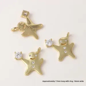 Détail de trois breloques bonshommes en pain d'épices dorés sertis de zircons et dimensions 17x18mm