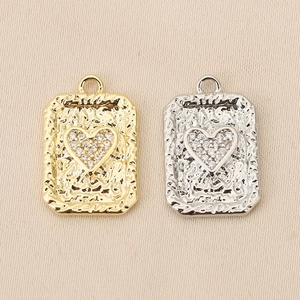 Vista detallada de colgantes de corazón de oro y plata con circonitas micro-pave para joyas DIY