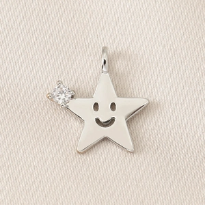 Vue macro d'un pendentif en forme d'étoile avec un visage souriant et un zircon blanc poli