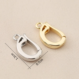 Macro detail of U-shaped gold and silver jewelry clasps with precise size 1.2cm x 0.7cm