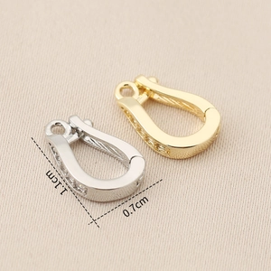 Detail view of 1.1x0.7cm gold and silver U-shaped jewelry clasps with cubic zirconia stones