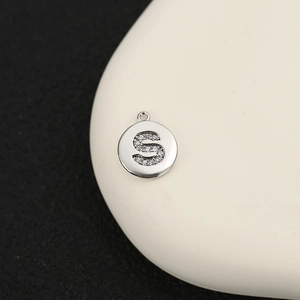 Primer plano de un colgante de letra S en plata con circonitas blancas para joyería DIY