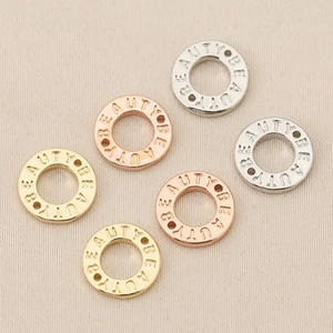 Dettaglio di perline a ciambella placcate oro 18K incise BEAUTY per fare gioielli