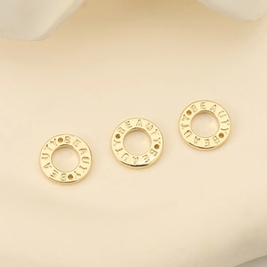 Dettaglio del ciondolo ad anello placcato oro 18K con incisione Beauty per gioielli