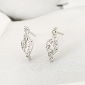 Vue détaillée de boucles d'oreilles vagues argentées avec zircons blancs micro-pavés