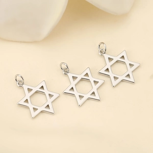 Macro detail of three polished silver hexagram pendants for DIY jewelry crafting