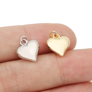 Detailed macro view of heart-shaped gold and silver pendants for DIY jewelry necklaces