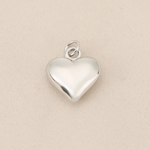 Close-up of a silver heart-shaped solid copper pendant with double rings for necklaces