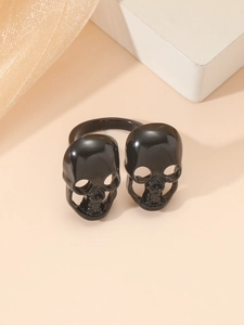 Primer plano detallado de un anillo negro brillante con doble calavera de estilo punk