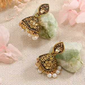 Detail of vintage gold Jhumka earrings with champagne rhinestones and white pearls