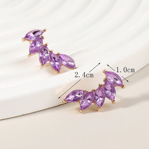 Macro shot of gold wing earrings with purple crystals and dimensions 2.4cm by 1.0cm
