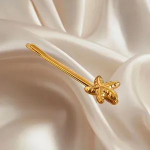 Eleganter goldener Seestern-Haarclip aus Metall auf Seidenstoff mit maritimem Design
