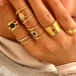Primo piano di anelli vintage placcati in oro 18k con gemme colorate sulla mano
