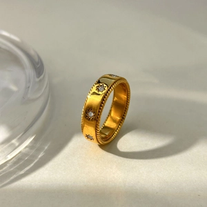 Polished 18K gold plated stainless steel ring with twisted edges and starburst set stones