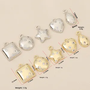 Macro detail of 18k gold plated charms with zircon stones in star and heart shapes