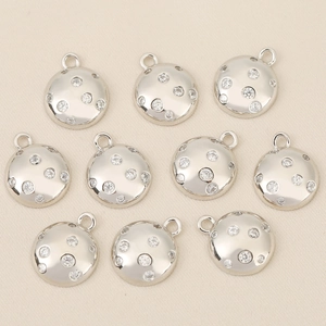 Close-up of 10 silver plated round pendants with micro-paved zircons for DIY jewelry