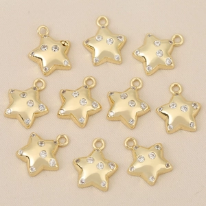 Close-up of ten 18k gold-plated star pendants with sparkling cubic zirconia for DIY jewelry