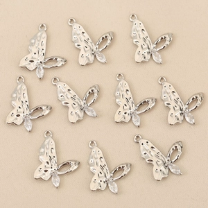 Détail de breloques papillon argentées avec zircon brillant et texture d'aspect martelé