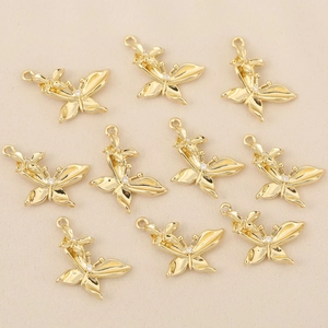 Gros plan détaillé de 10 pendentifs papillon plaqués or ornés de zircons étincelants