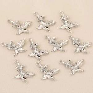Gros plan de pendentifs papillons argentés avec zircons et dorure à l'or 18 carats