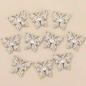 Vue détaillée de 10 pendentifs papillon argentés avec zircon rond sur tissu de soie