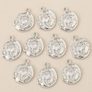 Dettaglio di pendenti a fiore in argento con zirconi incastonati e bordi irregolari