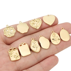Set aus 18 Karat vergoldeten Blumenanhängern in der Hand für den Größenvergleich