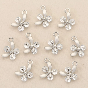 Detailed view of silver flower charms with inlaid zircons for DIY jewelry making