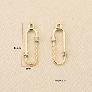Macro detail of 18k gold plated U-shape safety pin charms with zircon 14mm x 5mm size