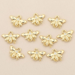 Macro view of ten gold-plated bee charms with zircon stones for DIY jewelry making