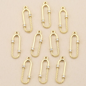 Ten pieces of gold plated safety pin pendants with twisted texture and cubic zirconia crystals
