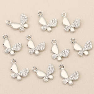 Macro view of butterfly charms with silver finish and pavé cubic zirconia for DIY jewelry