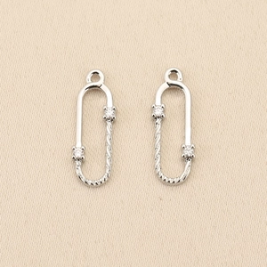 Macro detail of silver U-shaped twisted chain link pendants with sparkling zircon inlays