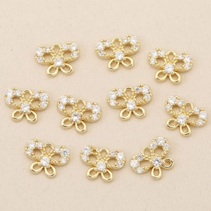 Macro shot of 10 gold plated bow-shaped pendants with micro-pave cubic zirconia stones
